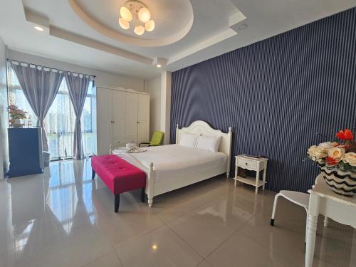 a bedroom with a white bed and a red bench at ToffyHome in Phetchabun