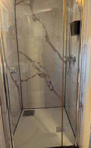 a shower with a glass door in a bathroom at PipowagenSiëester in Ommen