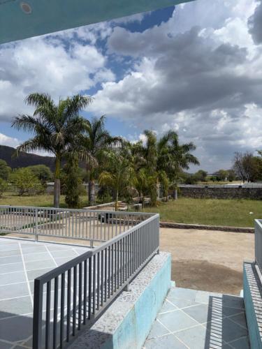a tennis court with palm trees in the background at The Celestine Villa in Thūr