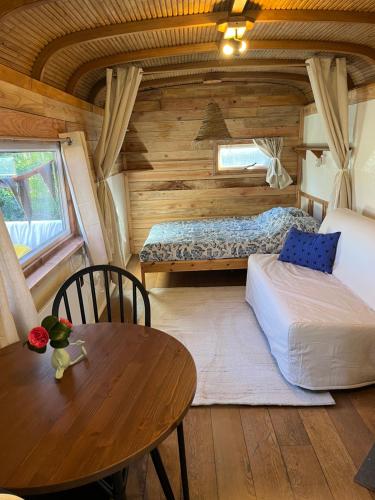 a bedroom in a log cabin with a table and a bed at PipowagenSiëester in Ommen