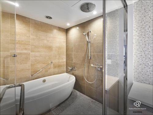 a bathroom with a bath tub and a shower at Daiwa Roynet Hotel Sendai Ichibancho PREMIER in Sendai