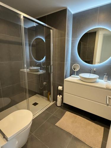 a bathroom with a toilet and a sink and a shower at Sea Breeze - Espinho Beach in Espinho