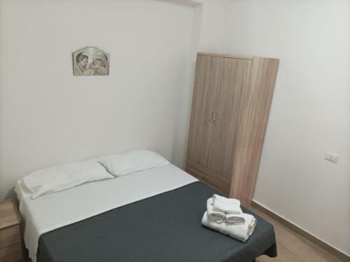 a small bedroom with a bed and a wooden cabinet at Brezza Marina in Cirella