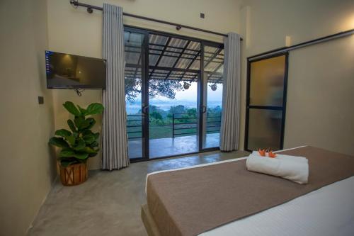 a bedroom with a bed and a large window at Hill Top Legacy in Ambalangoda