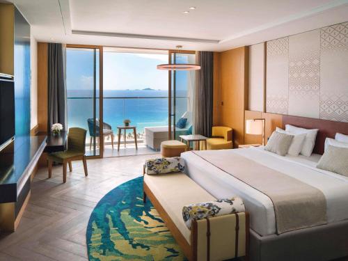 a bedroom with a large bed with a view of the ocean at Mövenpick Resort Cam Ranh in Cam Ranh