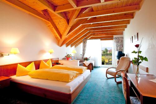 ヴァッサーブルクにあるHotel-Restaurant Walserhofのベッドルーム1室(大型ベッド1台、黄色い枕付)