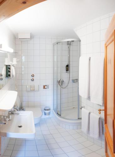 a bathroom with a shower and a sink and a toilet at Noon Mirch Hotel Restaurant in Eching