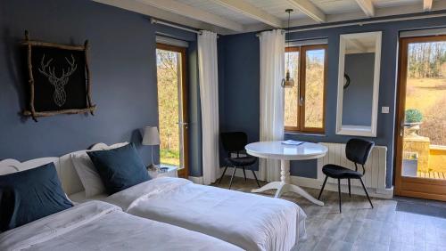 a bedroom with a bed and a table with chairs at BonBon Chambre d'hôtes in Saint-Julien-de-Lampon