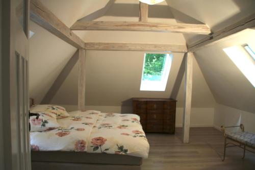 ein Schlafzimmer mit einem Bett im Dachgeschoss in der Unterkunft Villa Sonnenburg Gästehaus in Rathmannsdorf