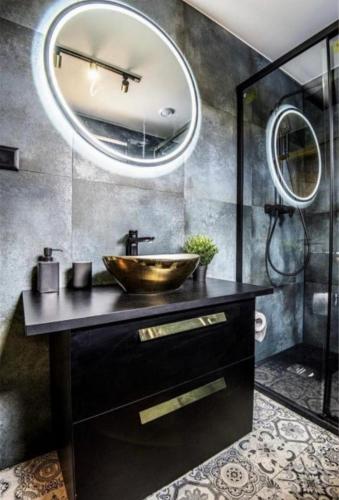 a bathroom with a sink and a large mirror at Dom U Piepki in Zdunowice Małe