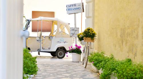 a white golf cart parked next to a building with flowers at Albergo Diffuso Monopoli in Monopoli