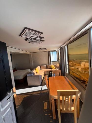 a room with a table and a couch and a dining room at private apparemment with ocean view in Taghazout