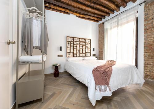 a bedroom with a bed and a brick wall at Apartamentos El Marqués in Granada