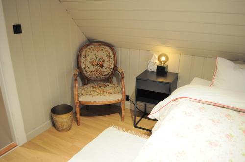 a bedroom with a chair and a bed and a nightstand at Eldhuset in Stavanger