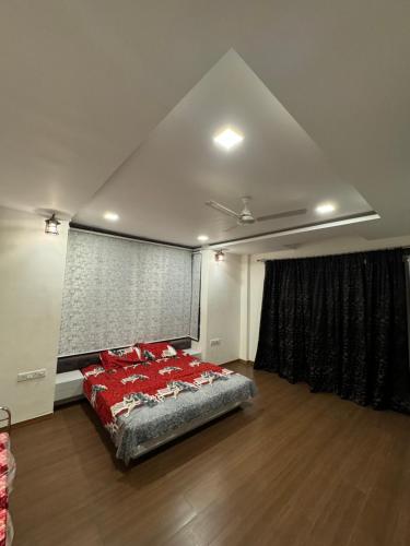 a bedroom with a bed with red pillows on it at Infinity farm and garden in Bhopal