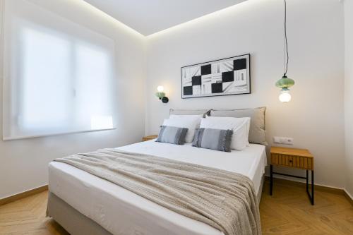 a white bedroom with a large bed with two pillows at Memoa Residence Preveza in Preveza