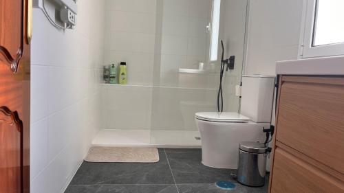a white bathroom with a toilet and a sink at Villa Alhelí del Aljarafe in Mairena del Aljarafe
