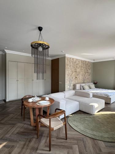 a living room with a white couch and a table at Rambynas R36 SELF CHECK-IN in Panevėžys