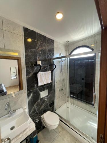 a bathroom with a shower and a toilet and a sink at Taksim Nu Pera Hotel in Istanbul