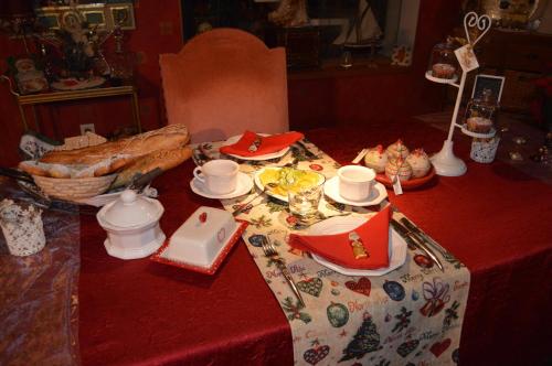 a table with a red table cloth with food on it at Côté vignes in Marlenheim