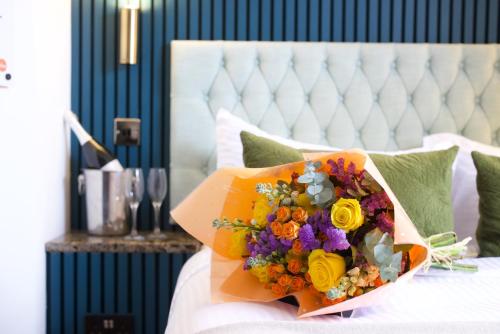 a bouquet of flowers sitting on top of a bed at City Rooms by Hiive in Worcester