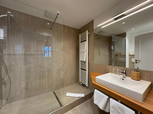 a bathroom with a sink and a shower at Hotel Spiegel Garni in Lindau