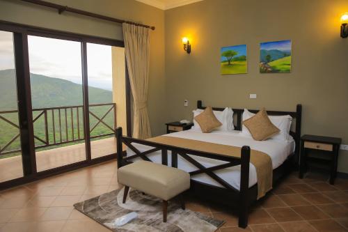 a bedroom with a large bed and a balcony at Haile Resort Arbaminch in Migie