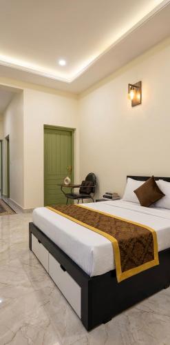 a bedroom with a large bed and a chair at Skylora Heights Inn in Kozhikode