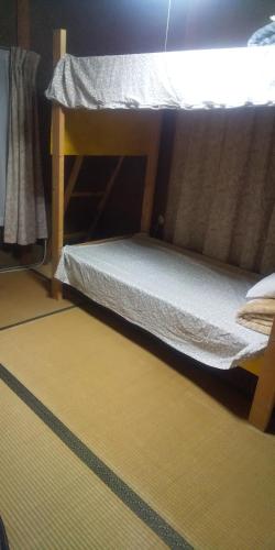 a bunk bed in a room with a yellow floor at raibrasil guest house in Sanuki