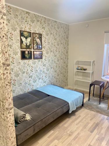 a bedroom with a large bed in a room with wallpaper at City centre one room apartment in Tartu