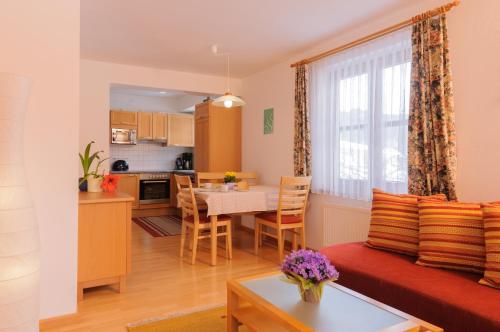 アルテンマルクト・イム・ポンガウにあるEisenhof apartmentsのリビングルーム(ソファ、テーブル付)、キッチンが備わります。