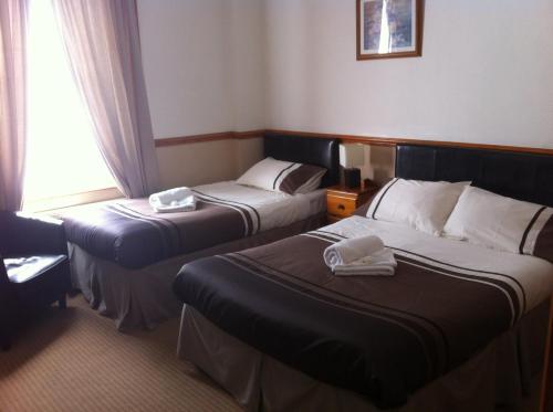 a hotel room with two beds and a window at Dover's Restover Bed & Breakfast in Dover