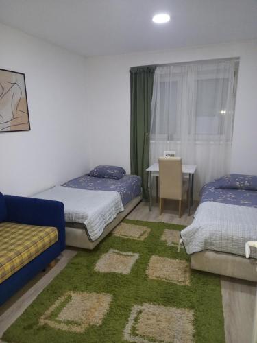 a bedroom with two beds and a table with a chair at Soul in Bela Crkva