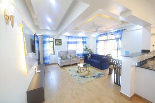 a living room with a blue couch and a table at Topaz Apartments Shanzu in Mombasa