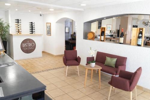 a waiting room with two chairs and a table at The Originals City, Hôtel Valence Est in Valence