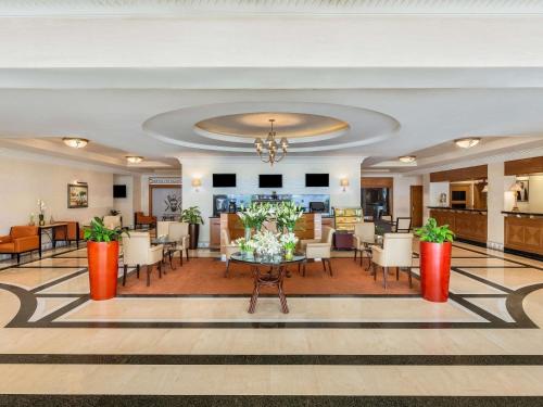 eine Hotellobby mit einem Tisch und Stühlen in der Unterkunft Mövenpick Hotel Doha in Doha