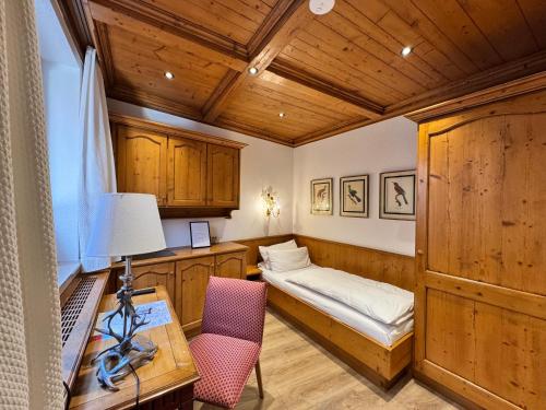 a room with a bed and a desk and a table at Hotel Spiegel Garni in Lindau