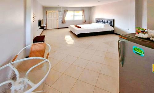 a large room with a bed and a refrigerator at V Village Hotel Saraburi in Ban Muak Lek