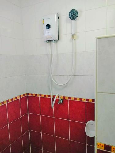 a shower in a bathroom with a red and white tiles at V Village Hotel Saraburi in Ban Muak Lek