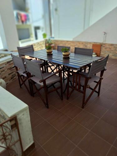 a wooden table and chairs with plants on it at Naxian Harmony 300m from the beach in Naxos Chora