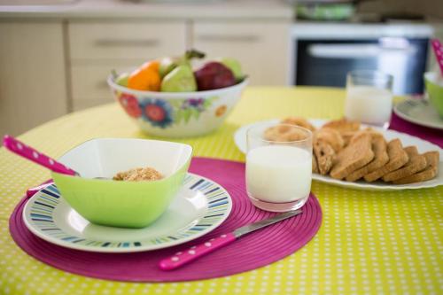 a table with a bowl of fruit and a bowl of milk at ZEN, Oneiropagida, Aegina in Vathí