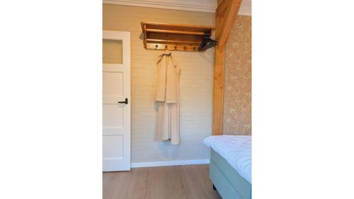 a bathroom with a towel hanging on a wall at Bungalow Doris with Hot Tub | 4 persons in Gasselte