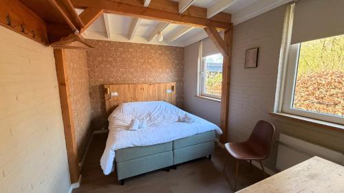 a small room with a bed and a chair in it at Bungalow Doris with Hot Tub | 4 persons in Gasselte