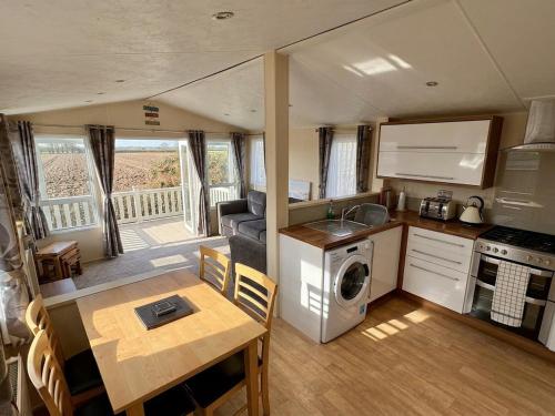 a kitchen and living room in a tiny house at Bluebird Skies - A cosy getaway in Great Yarmouth