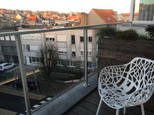 a white chair sitting on top of a balcony at ABC Hotel in Blankenberge