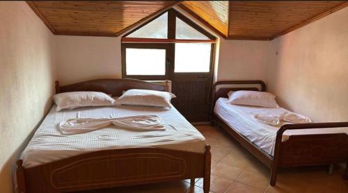 two twin beds in a room with a window at Deda Apartaments in Shëngjin