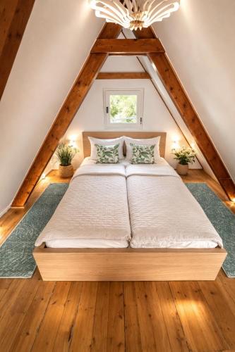 a bedroom with a large bed in the attic at Spicc house in Csopak