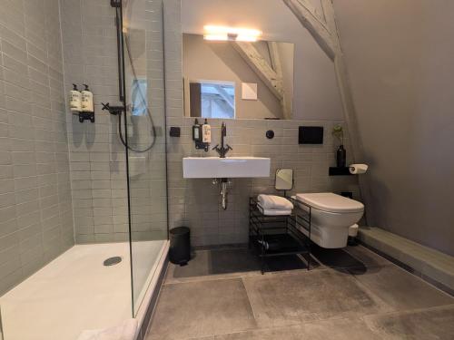 ein Badezimmer mit Dusche, Waschbecken und Toilette in der Unterkunft Fisher's Loft Hotel in Lübeck