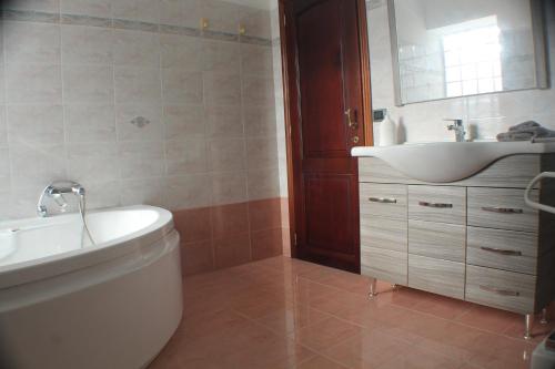 a bathroom with a sink and a tub and a toilet at Camera confortevole tra Roma e Ostia in Acilia