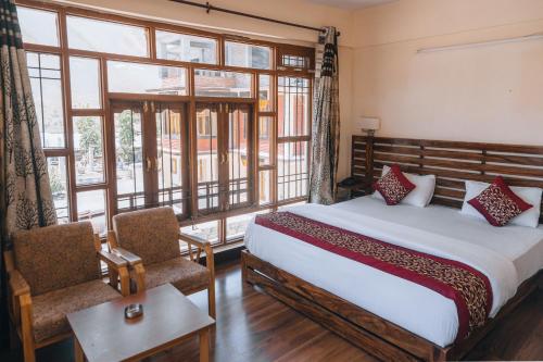 a bedroom with a bed and a large window at Hotel Heritage in Kaza